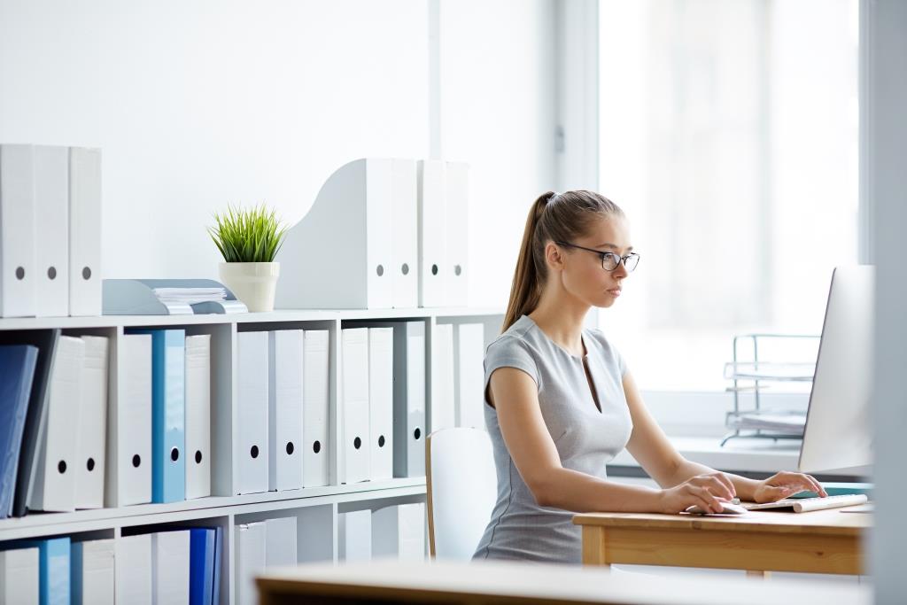 Serious businesswoman sitting in front of laptop in office