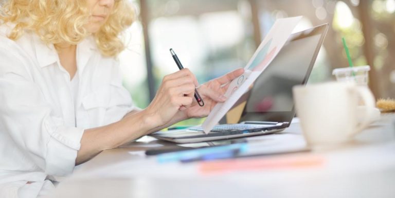 Businesswoman working in office with laptop computer and documents