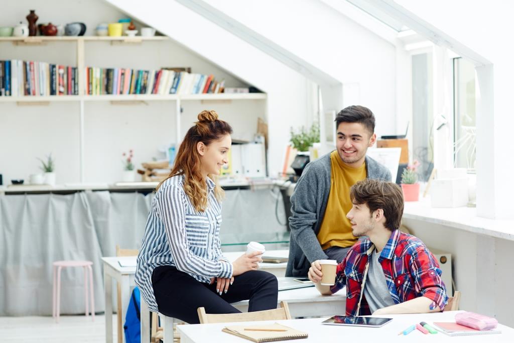 Young woman and two men having discussion at break