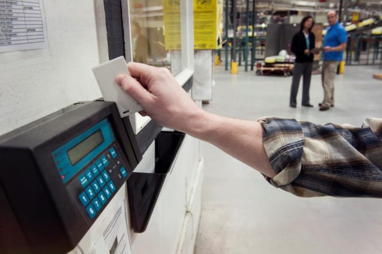 Person clocking in at a factory, time clock card