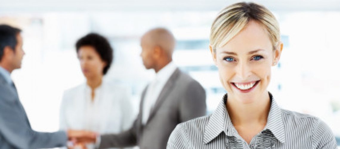 iStock_000009782909XSmall Portrait of a cute business woman with team in discussion at the back